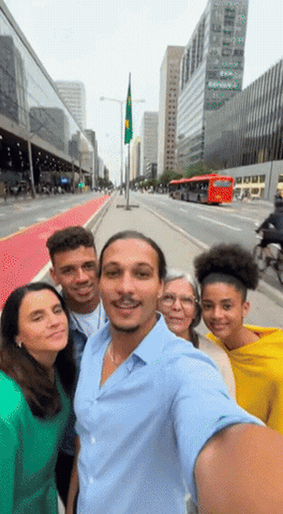 A Group Of People Are Posing For A Selfie In Front Of A City Street GIF