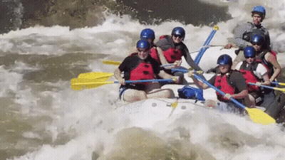 A Group Of People Are Rafting Down A River In A White Raft GIF