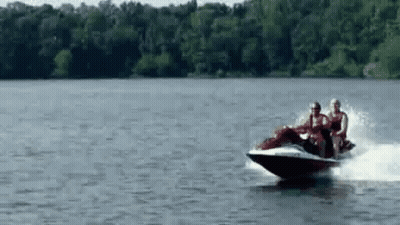 A Group Of People Are Riding A Jet Ski In The Water . GIF