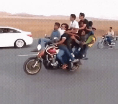 A Group Of People Are Riding A Motorcycle On The Road . GIF