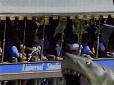 A Group Of People Are Riding A Trolley That Says Universal Studios GIF