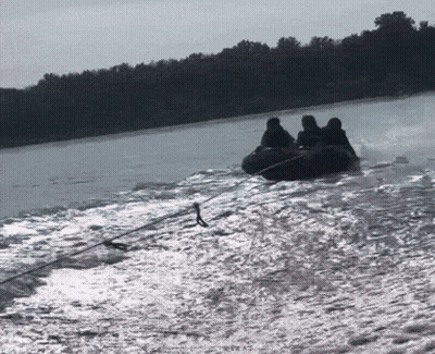 A Group Of People Are Riding A Tube On A Lake GIF