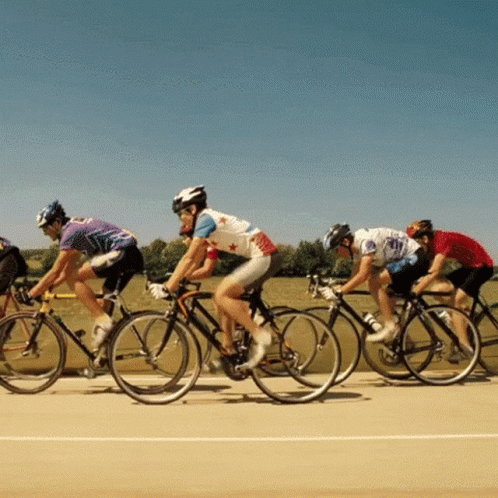 A Group Of People Are Riding Bikes On A Track GIF
