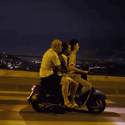 A Group Of People Are Riding On A Scooter At Night GIF
