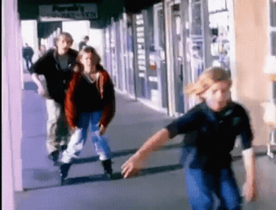 A Group Of People Are Rollerblading Down A Sidewalk In Front Of A Store That Says ' Purah 'S ' On It GIF