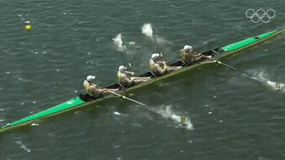 A Group Of People Are Rowing A Boat In The Water GIF