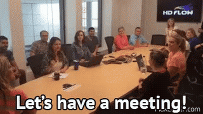 A Group Of People Are Sitting Around A Conference Table And They Are Saying Let 'S Have A Meeting . GIF