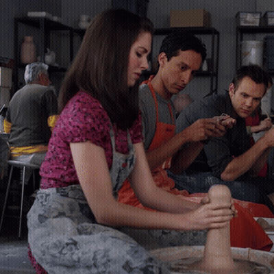 A Group Of People Are Sitting Around A Pottery Wheel Making Clay Sculptures GIF