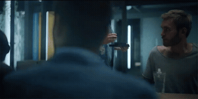 A Group Of People Are Sitting Around A Table And One Man Is Holding A Bottle Of Water GIF