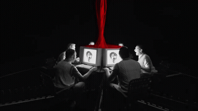 A Group Of People Are Sitting Around A Table Looking At Computers GIF