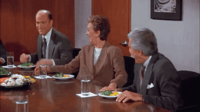 A Group Of People Are Sitting Around A Table With Plates Of Food And Glasses Of Water . GIF
