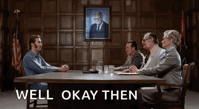 A Group Of People Are Sitting Around A Table With The Words Well Okay Then Written On The Bottom GIF