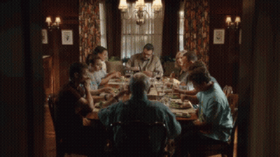 A Group Of People Are Sitting At A Table Eating Food GIF
