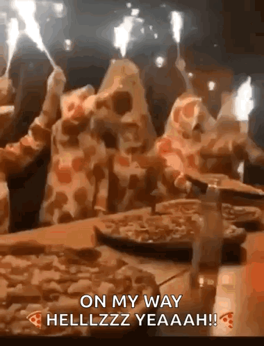 A Group Of People Are Sitting At A Table Eating Pizza With Sparklers . GIF