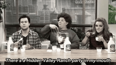 A Group Of People Are Sitting At A Table Eating Ranch GIF