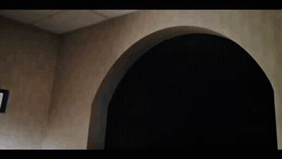 A Group Of People Are Sitting At A Table In A Dark Room With Arches . GIF