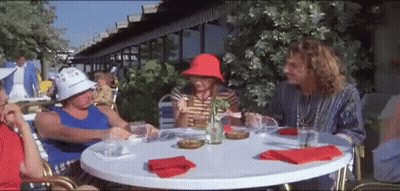 A Group Of People Are Sitting At A Table With Drinks And Napkins . GIF