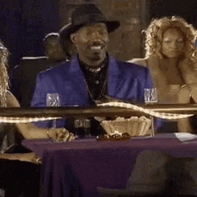 A Group Of People Are Sitting At A Table With The Word Yea Written On The Bottom GIF