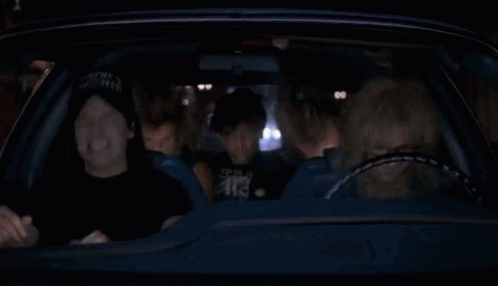 A Group Of People Are Sitting In A Car At Night And Laughing . GIF