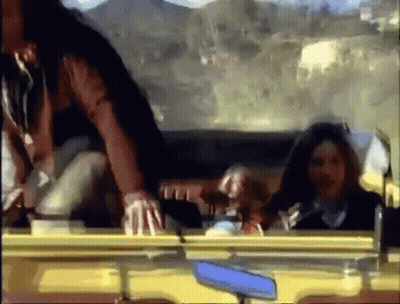 A Group Of People Are Sitting In A Car Looking Out The Window GIF
