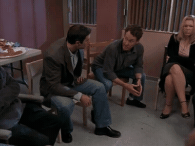 A Group Of People Are Sitting In A Circle And Talking GIF