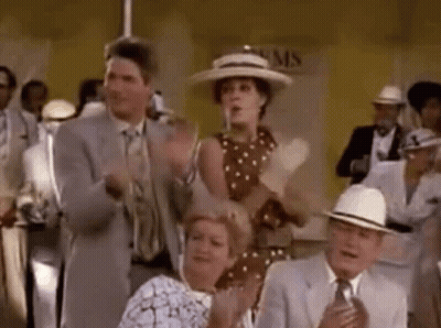 A Group Of People Are Sitting In A Room Clapping Their Hands In A Crowd . GIF
