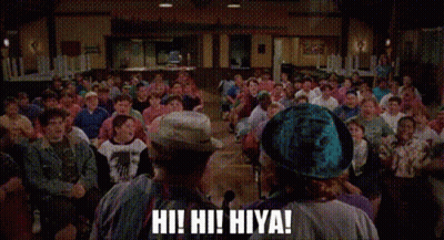A Group Of People Are Sitting In A Room With Their Arms In The Air And One Of Them Is Shouting . GIF
