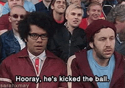 A Group Of People Are Sitting In A Stadium And One Of Them Is Saying " Hooray He 'S Kicked The Ball GIF