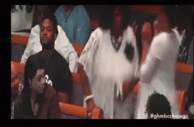 A Group Of People Are Sitting In A Stadium Watching A Game And Talking To Each Other . GIF