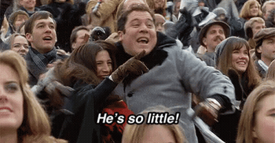 A Group Of People Are Sitting In A Stadium Watching A Game . GIF