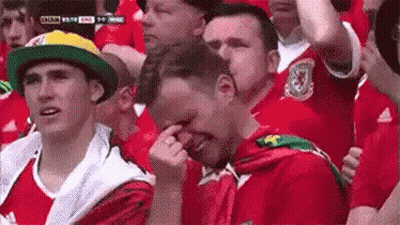 A Group Of People Are Sitting In A Stadium Watching A Soccer Game . GIF