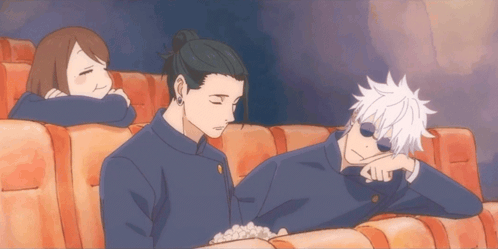 A Group Of People Are Sitting In A Theater Watching A Movie GIF