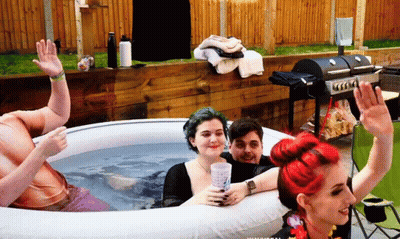 A Group Of People Are Sitting In An Inflatable Tub GIF