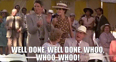 A Group Of People Are Sitting In Chairs And A Man Is Standing In Front Of Them . GIF
