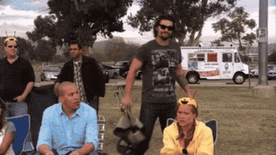 A Group Of People Are Sitting In Chairs In A Park . GIF