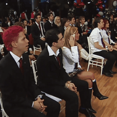 A Group Of People Are Sitting In Chairs Watching A Presentation GIF