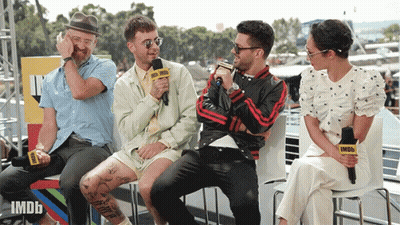 A Group Of People Are Sitting In Front Of A Microphone That Says Imdb GIF