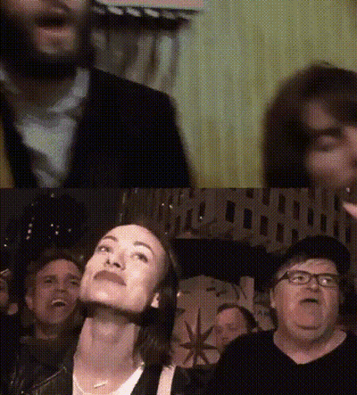 A Group Of People Are Sitting In Front Of A Sign That Says " Hollywood " GIF