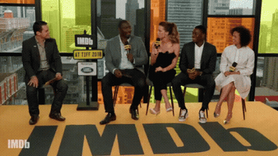 A Group Of People Are Sitting In Front Of A Sign That Says Imdb GIF