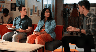A Group Of People Are Sitting On A Couch In A Hallway GIF