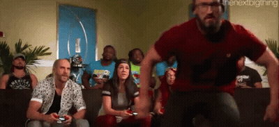 A Group Of People Are Sitting On A Couch Playing A Video Game While A Man In A Red Shirt Is Running Towards Them GIF