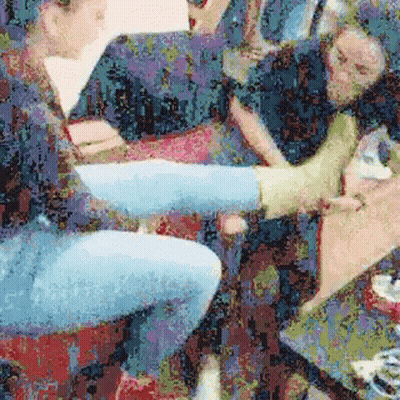 A Group Of People Are Sitting On A Couch With Their Legs Crossed And Their Feet Up . GIF