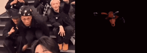 A Group Of People Are Sitting On A Set Of Stairs Next To A Red Monster With The Number 10 On Its Face GIF