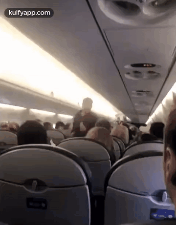 A Group Of People Are Sitting On An Airplane And The Website Kulfyapp.com Is Displayed In The Corner GIF