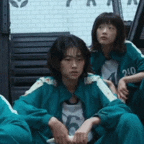 A Group Of People Are Sitting On The Floor In A Room . GIF