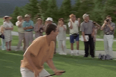 A Group Of People Are Standing Around A Golf Course Watching A Man Play Golf . GIF
