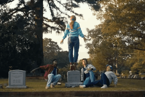 A Group Of People Are Standing Around A Grave That Says John R. Cole On It GIF