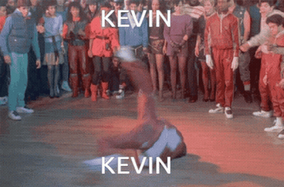 A Group Of People Are Standing Around A Man Doing A Trick With The Name Kevin Written Above Him GIF