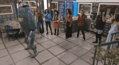 A Group Of People Are Standing Around A Robot Dancing GIF