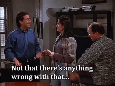 A Group Of People Are Standing Around A Table And One Of Them Says Not That There 'S Anything Wrong With That . GIF